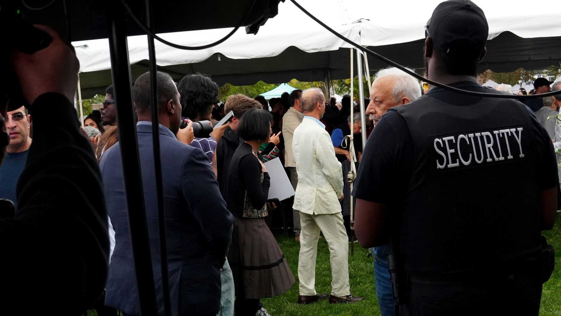 Ein Sicherheitsbeamter überwacht eine Versammlung unter einem Zelt.